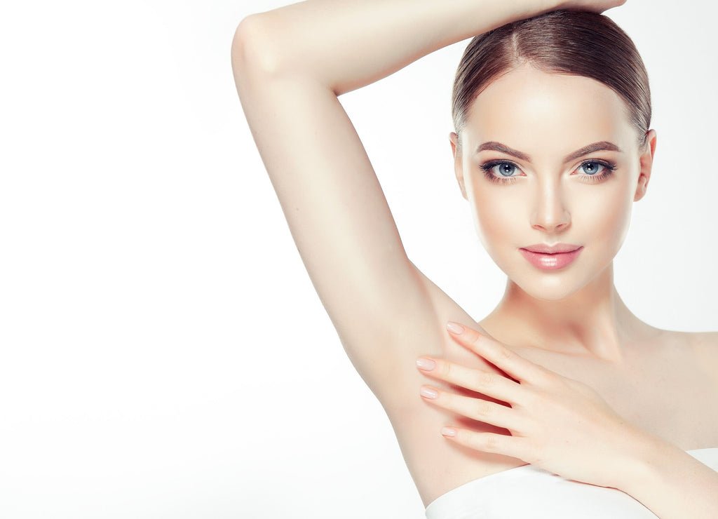 A woman admiring her smooth underarms after having Pain Free Laser Hair Removal
